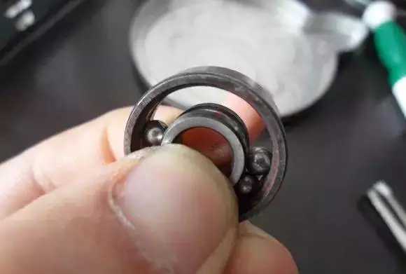 用手將軸承拿起，需要注意要向有滾珠的方向頂住